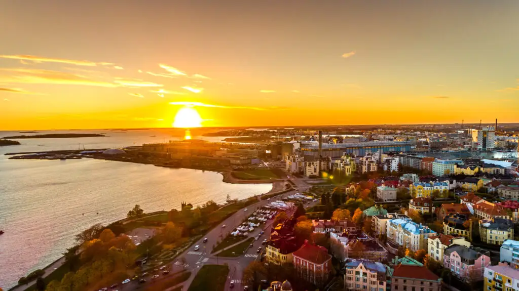 Aerial sunset view of Helsinki showcasing colorful skies and diverse architecture along the coastline, Helsinki, Finland.