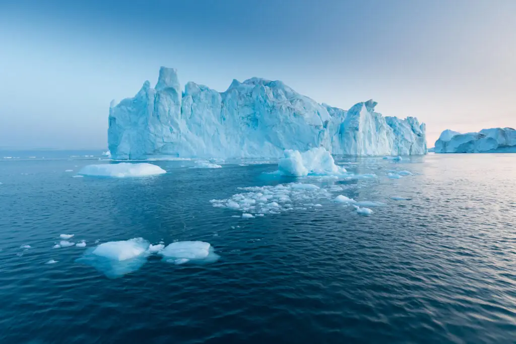 Majestic blue iceberg in serene arctic waters under a clear sky, a stunning natural attraction for Scandinavian private tours.