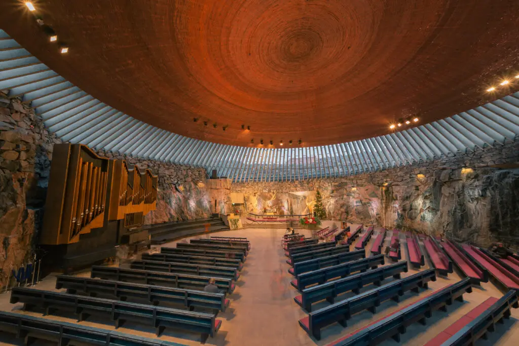 Interior view of the Rock Church (Temppeliaukion kirkko) with Christmas decorations, showcasing the architectural beauty and serene ambience, Helsinki, Finland.