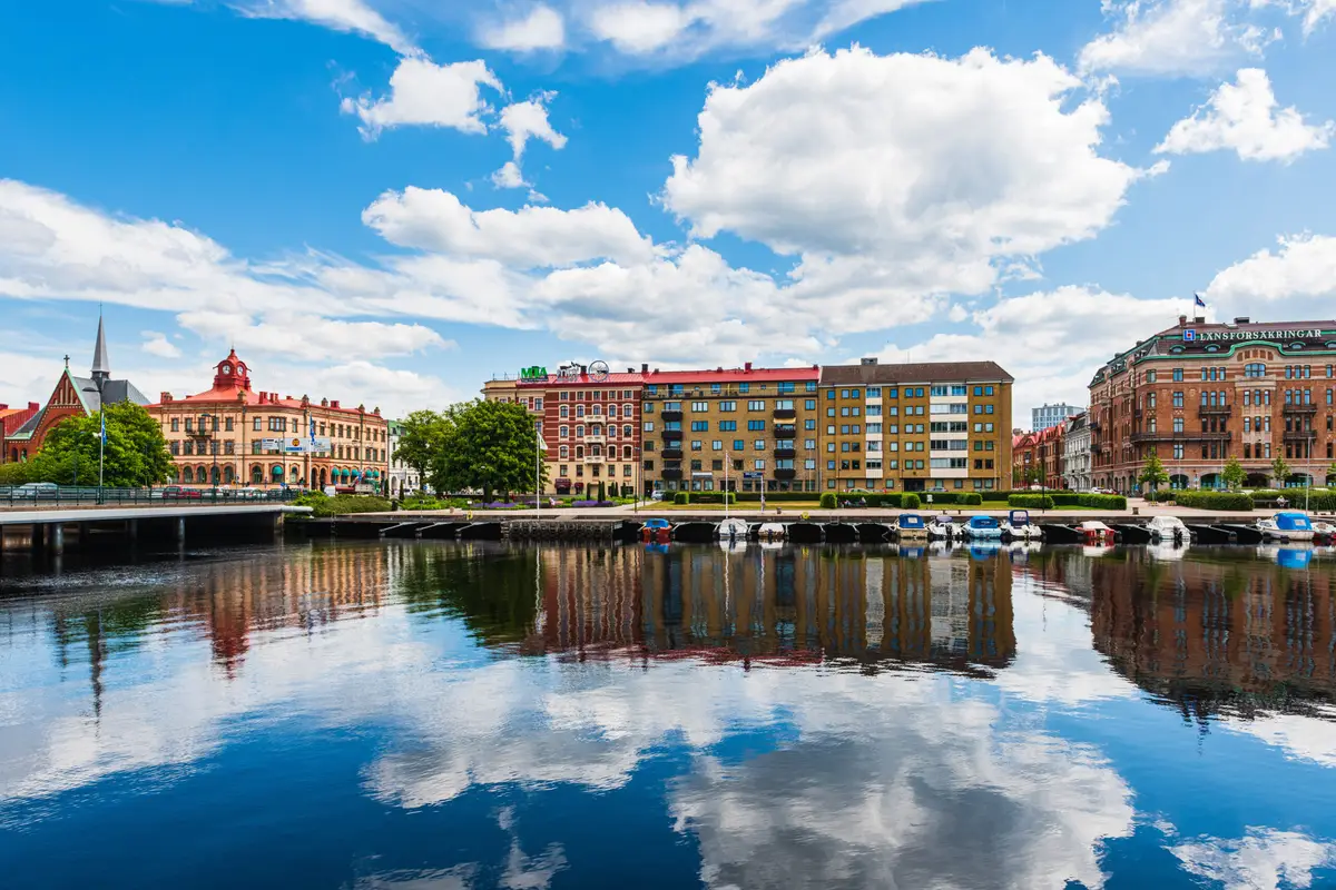 Colorful buildings reflecting in the still river at Halmstad, a popular tourism destination in Sweden