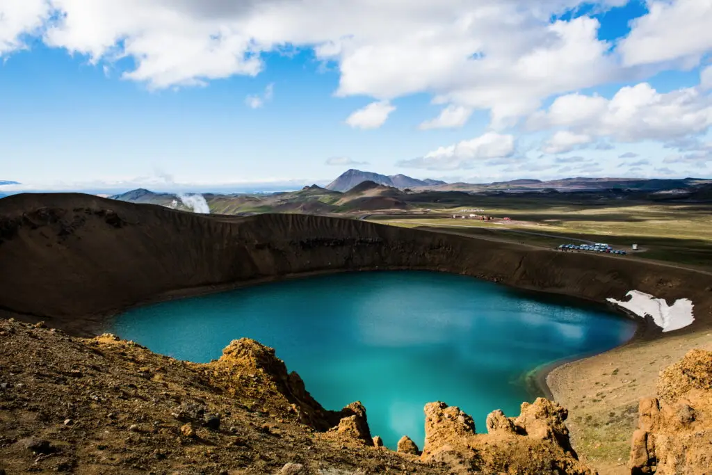Stunning view of Viti Crater at Krafla in Iceland, featuring a vivid turquoise lake surrounded by rugged volcanic terrain under a clear blue sky.
