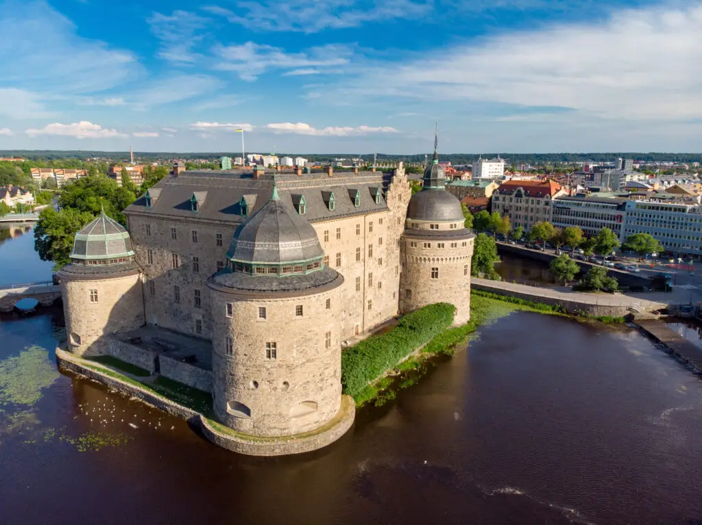 Aerial view of Örebro Castle in Sweden surrounded by water with cityscape in the background, highlighting Scandinavian heritage and architecture.