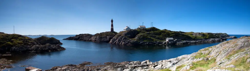 Panoramic view of Hellisøy lighthouse on rocky coastline of Fedje island in Hordaland, Norway, a popular destination for scenic tours in Scandinavia.