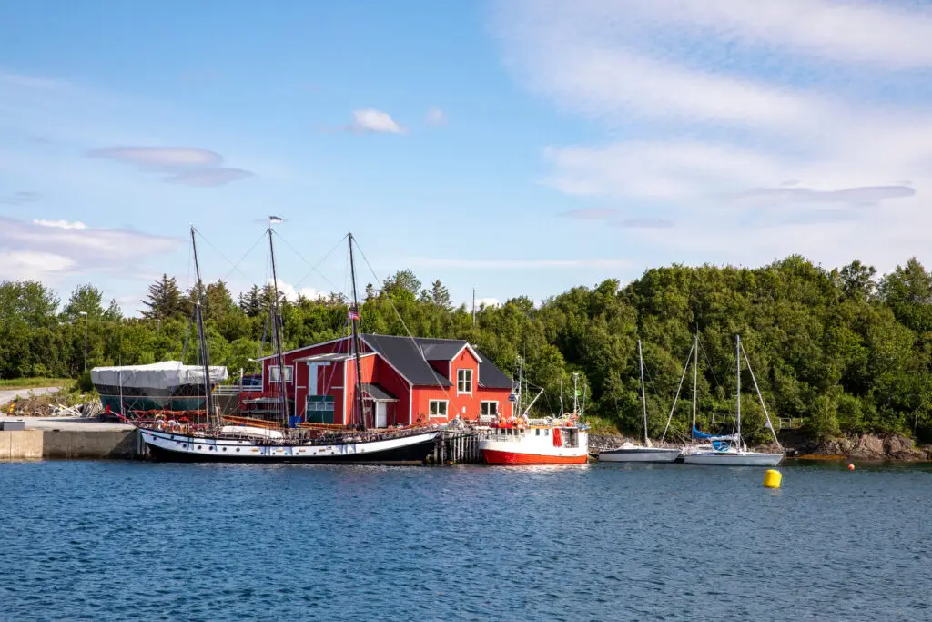 Scenic view of a traditional sailboat at a coastal workshop in Brønnøysund, Norway, showcasing maritime culture and Nordic scenery.