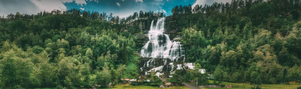 Panoramic view of Tvindefossen waterfall in Voss, Hordaland, Norway during spring, showcasing its cascading waters amidst lush greenery, a famous and scenic natural landmark in Norway and popular tourist destination.
