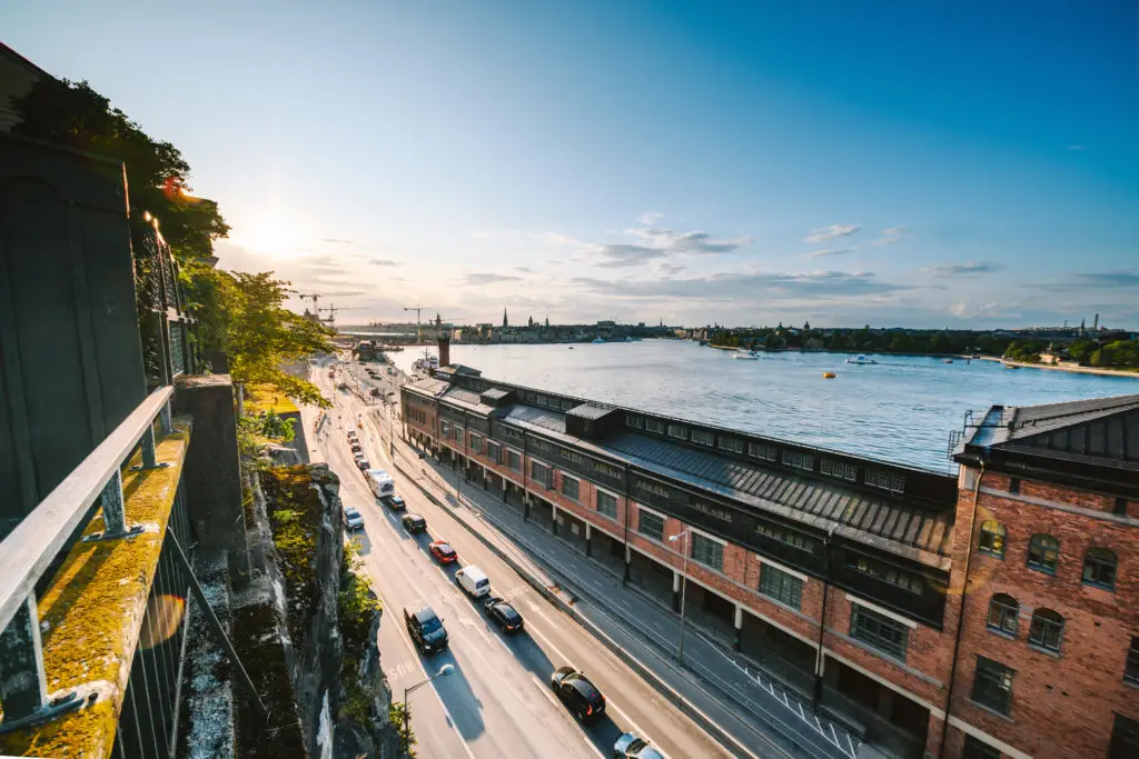 Sunset view over Stockholm showcasing the picturesque Fotografiska museum and the bustling waterfront street, highlighting Sweden's cultural and scenic beauty.