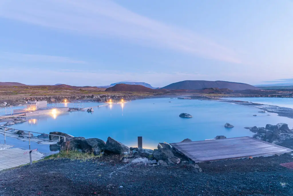 Tranquil sunset at Myvatn Nature Baths in Iceland, showcasing the serene blue geothermal waters and surrounding volcanic landscape.