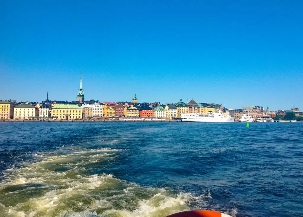 View of Stockholm skyline from a boat showcasing historical architecture and vibrant city life, perfect for travelers exploring Scandinavia.