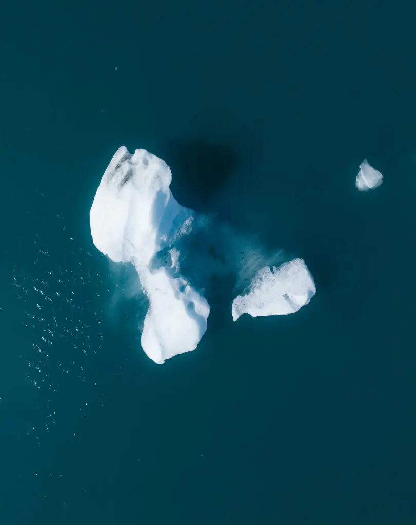 Aerial view of a melting iceberg in the Arctic, illustrating climate change impact, featured on Scandinavia Private Tours emphasizing global warming effects.