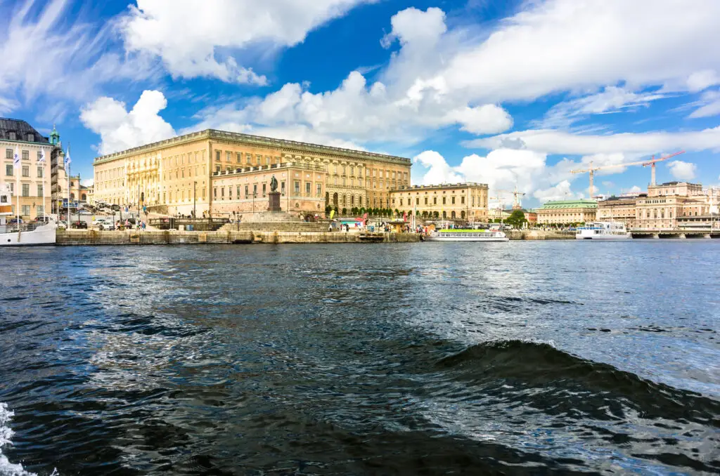 View of Stockholm Royal Palace in Sweden from the water, showcasing the grand architecture and bustling waterfront.