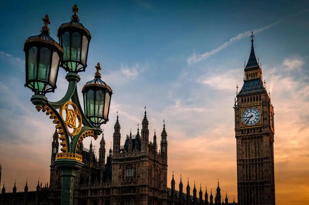Big Ben and the Houses of Parliament illuminated at sunset with a detailed vintage lamppost in foreground, London, England
