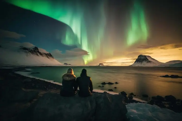 Two people sitting on a rock enjoying the Northern Lights over a snowy landscape in Scandinavia, ideal for customized private tours.