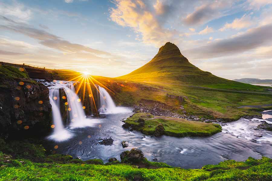 Sunset over Kirkjufellsfoss waterfall with Kirkjufell mountain in the background, Iceland, a popular scenic travel destination in Scandinavia.