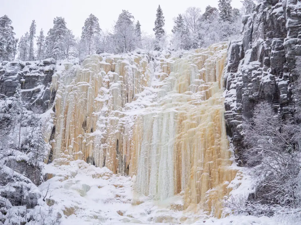 Stunning view of Korouoma Frozen Waterfalls in winter, showcasing the icy cascades and snow-covered cliffs at Korouoma Canyon, Finland.