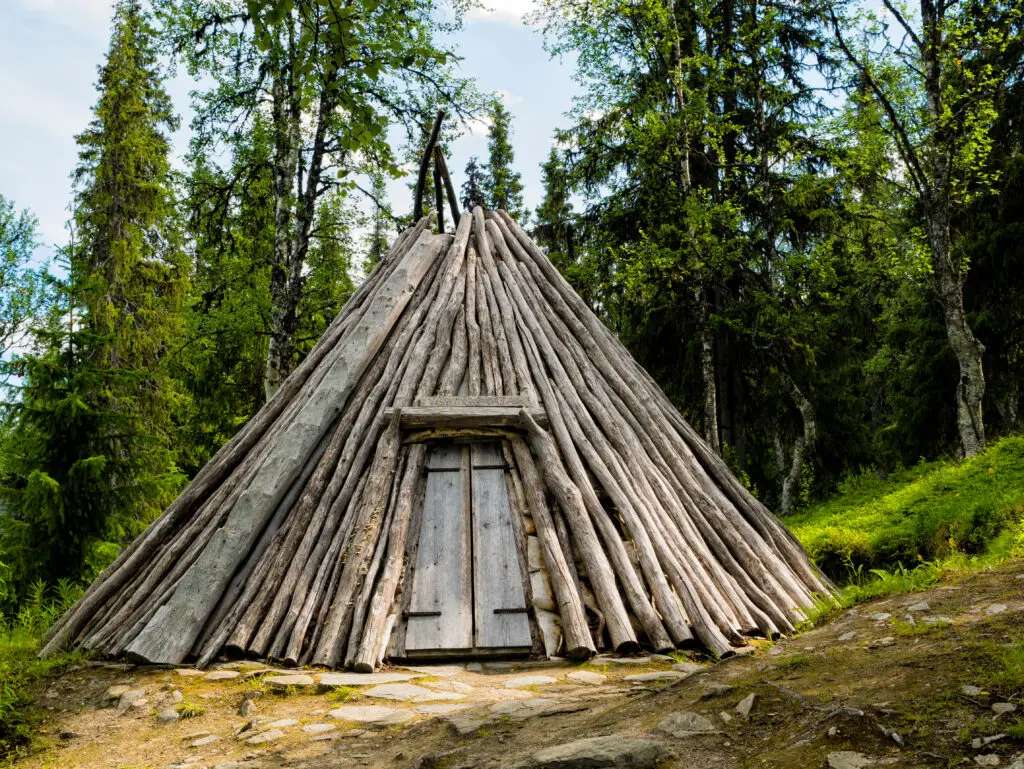 Traditional Sami Kota in Scandinavian forest, cultural heritage site in Scandinavia, ideal for exploring indigenous Lapland architecture on private tours.