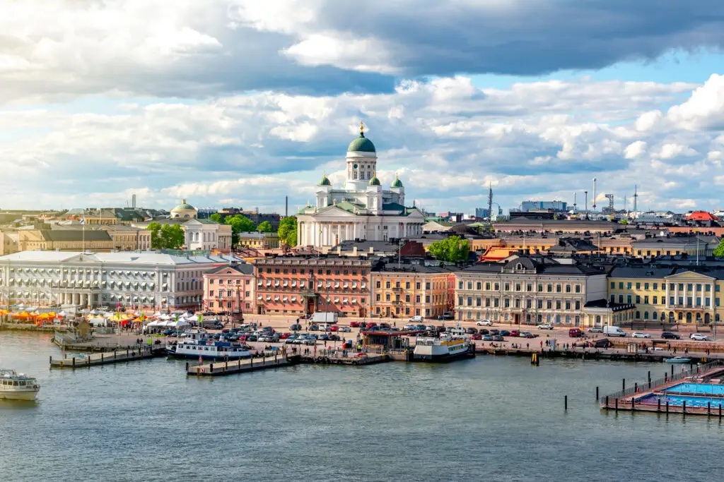 Panoramic view of Helsinki cityscape with Helsinki Cathedral and bustling market square by the waterfront in Finland.