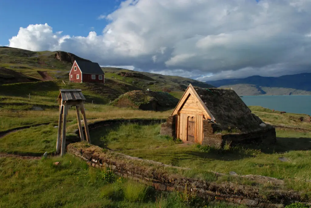 Replica of Thjodhild's Church in Brattahlid, Greenland, showcasing traditional Norse architecture against a backdrop of Erik's Fjord.