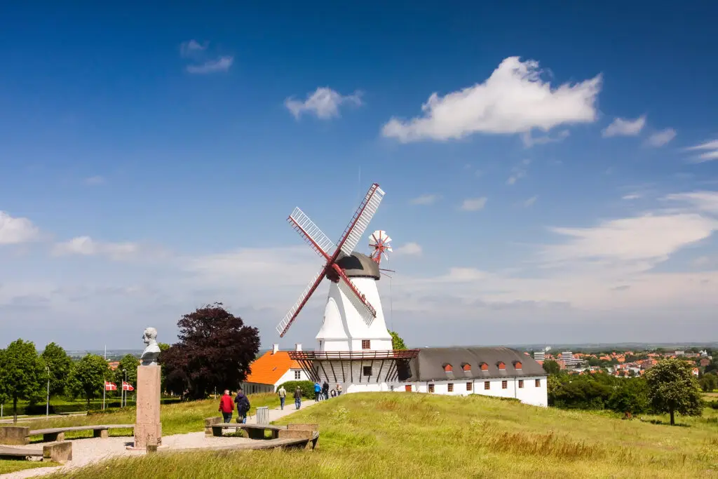 Dybbøl Mølle Windmill and museum, a significant Danish memorial on the cultural heritage managed battlefields of 1864 near Sønderborg, Denmark, with visitors exploring the scenic historical site.