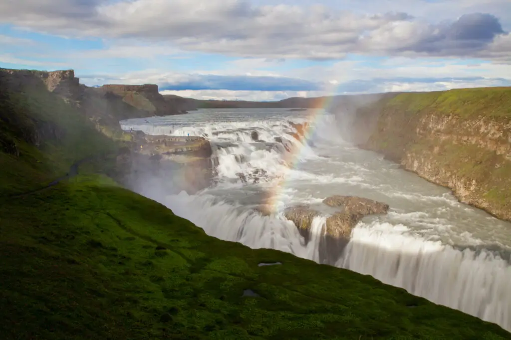 Breathtaking view of Urriðafoss Waterfall on the South Coast of Iceland with vibrant rainbow over cascading waters, ideal for nature lovers and scenic tours.