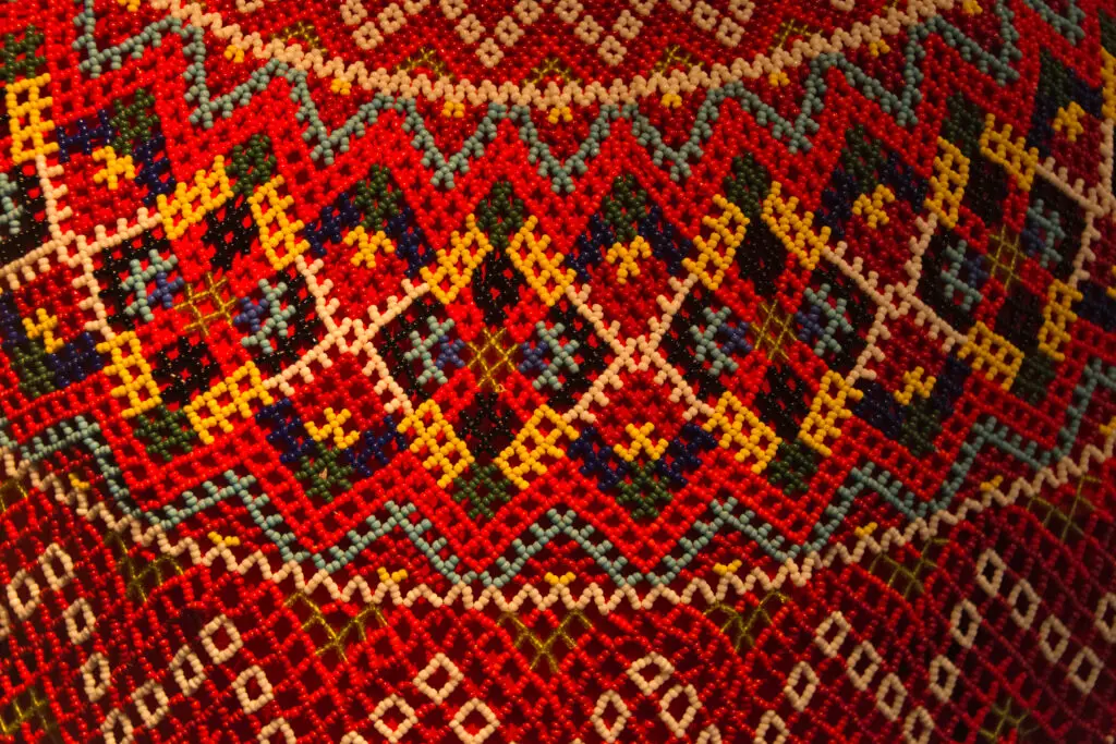 Close-up of a traditional Inuit beaded costume on display at the National Museum in Nuuk, Greenland, showcasing intricate beadwork patterns in vibrant colors.
