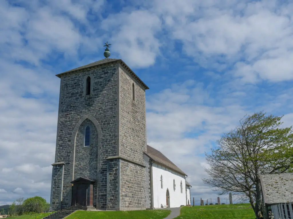 Stone church in Haugesund, Norway under a blue sky with clouds, showcasing historic Scandinavian architecture