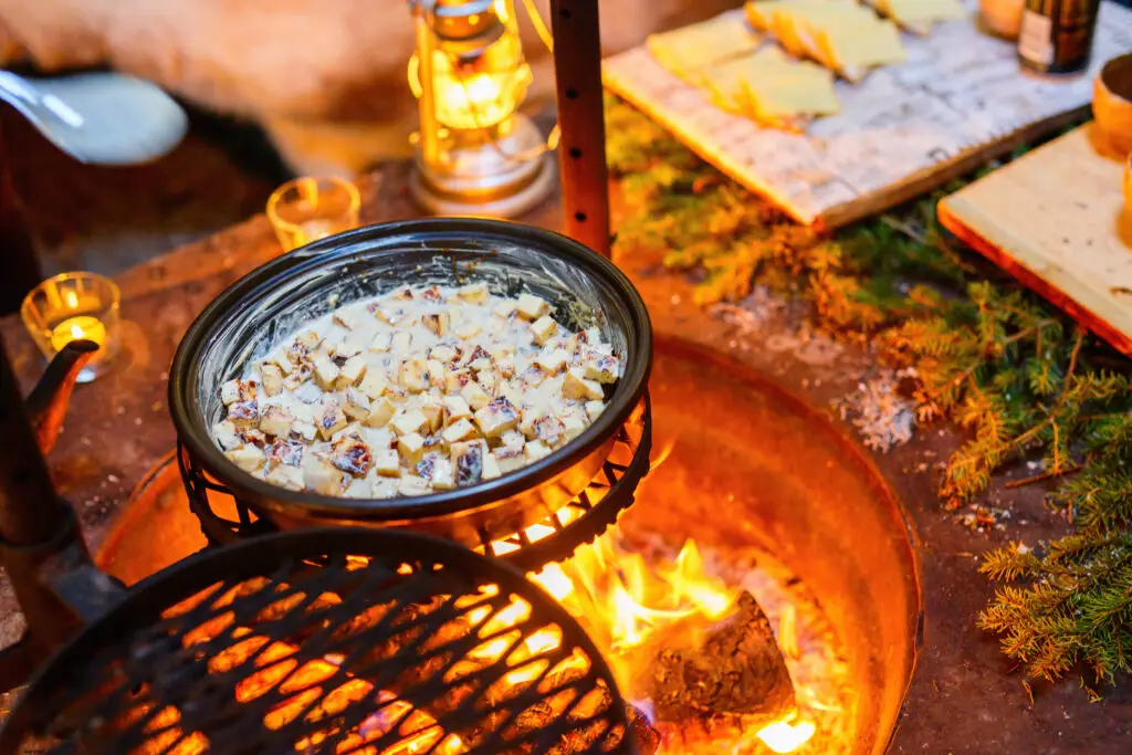 Traditional Lappish baked cheese with cloudberry jam served over an open fire in a Scandinavian outdoor setting