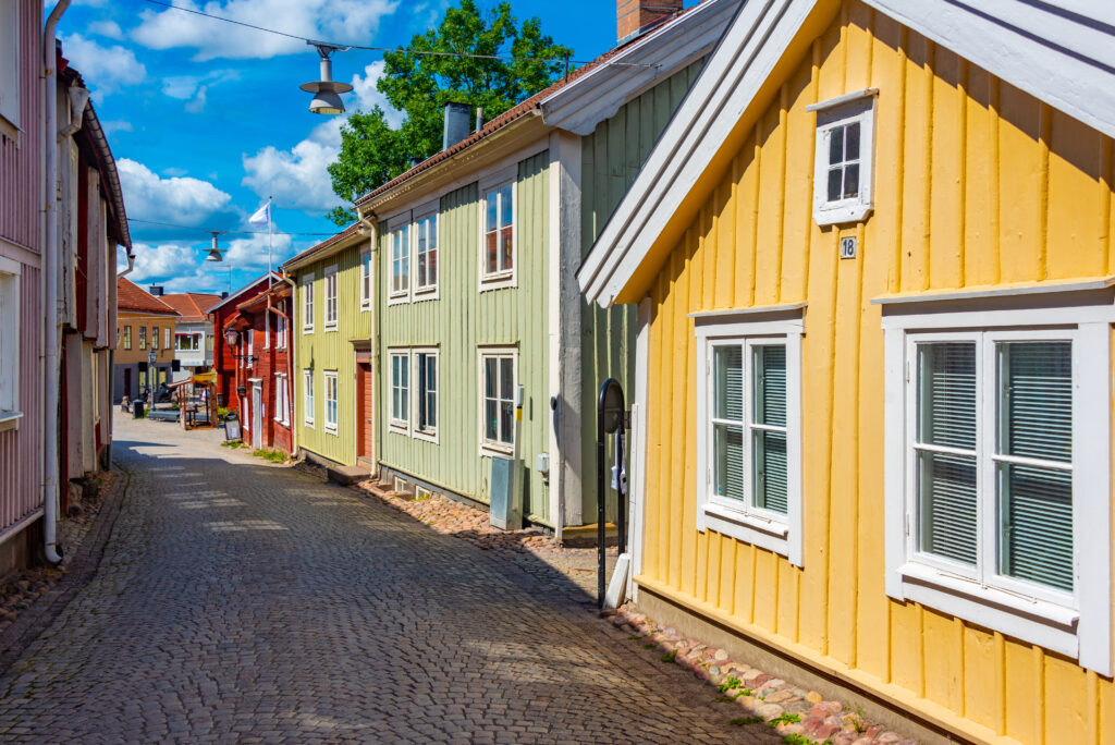 Colorful traditional Swedish timber houses lining a cobblestone street in Eksjö, a picturesque destination for cultural tourism in Scandinavia.