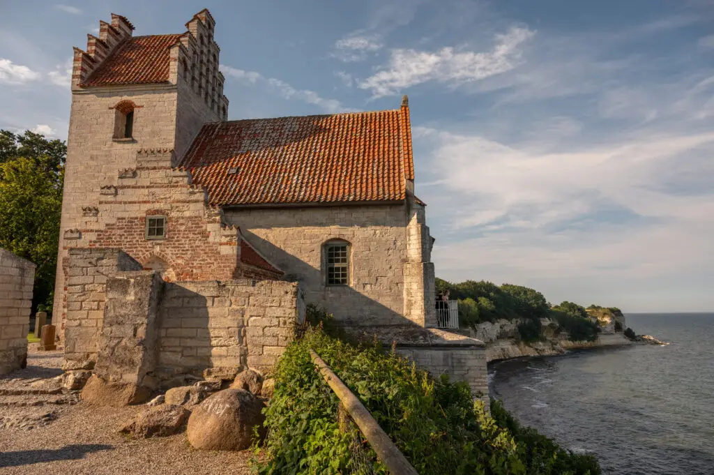 Historic Højerup Old Church on the cliff of Stevns Klint in Denmark, overlooking the Baltic Sea, perfect example of Scandinavia's cultural heritage and natural beauty.