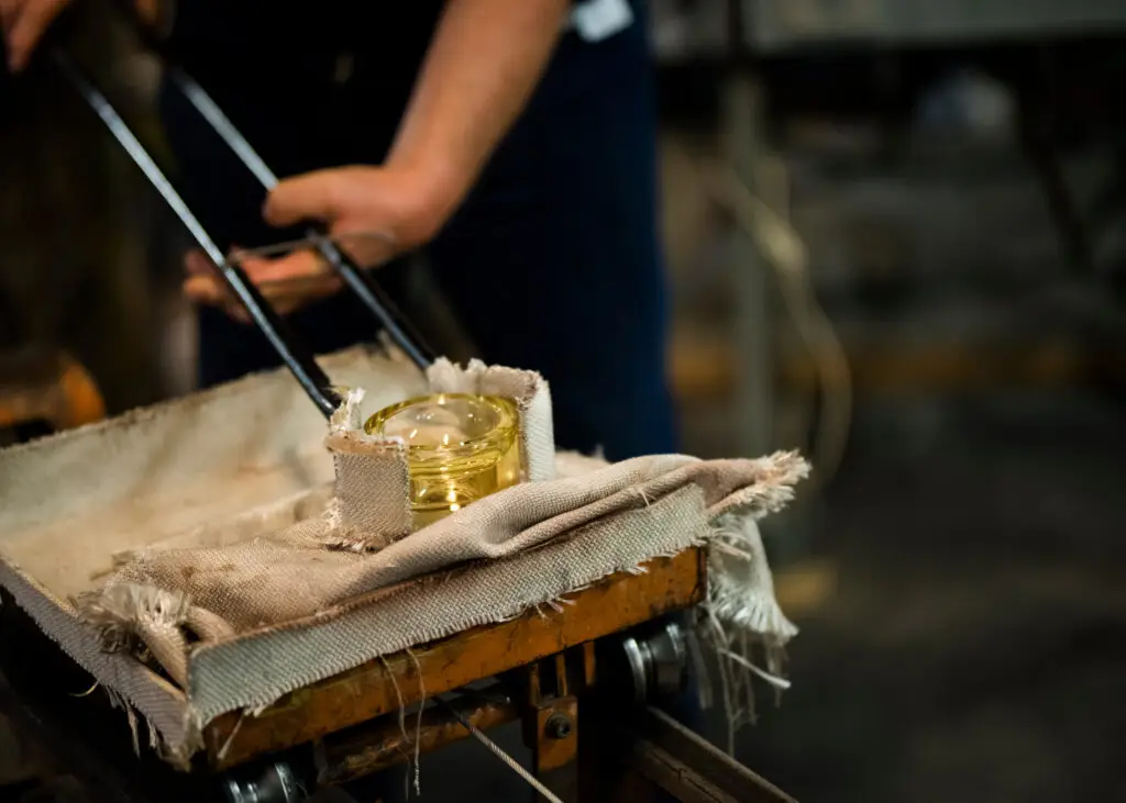 Glassblower in Sweden creating a lantern at the Reijmyre Glassworks, showcasing traditional Scandinavian craftsmanship and glassblowing technique.